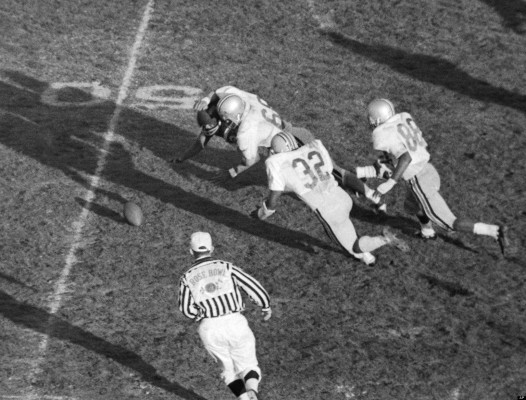 Halfback O.J. Simpson, almost hidden by Ohio State's middle guard Jim Stillwagon (68), fumbles as he's hit during Rose Bowl game in Pasadena, California on Jan. 1, 1969. Ohio State recovered and went on to score a field goal that put the Buckeyes in the lead. Other Ohio State players are linebacker John Tatum (32) and end Dave Whitfield. (AP Photo)