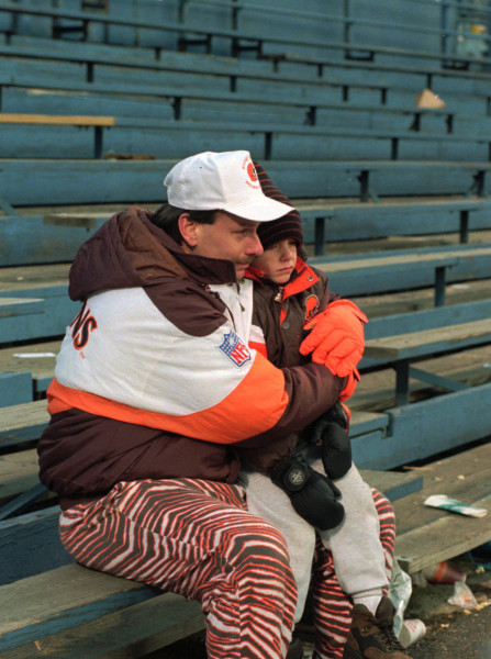 Joe Shapaka holds his six-year-old son, Matthew, at their seats in the bleachers at Cleveland Stadium after the Browns-Cincinnati Bengals game which may have been the final Cleveland Browns game there Sunday, Dec. 17, 1995. (AP Photo/Jeff Glidden)