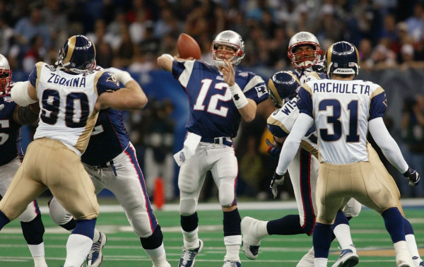 New England Patriots quarterback Tom Brady (12) throws as St. Louis Rams' Jeff Zgonina (90) and Adam Archuleta (31) defend during the third quarter of Super Bowl XXXVI at the Louisiana Superdome, Sunday, Feb. 3, 2002, in New Orleans. (AP Photo/Doug Mills)