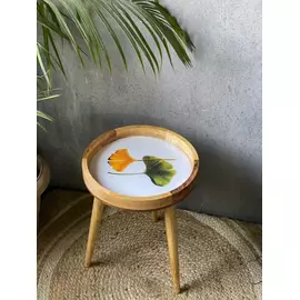 Mesa de madera con estampado de hojas verdes y amarillas