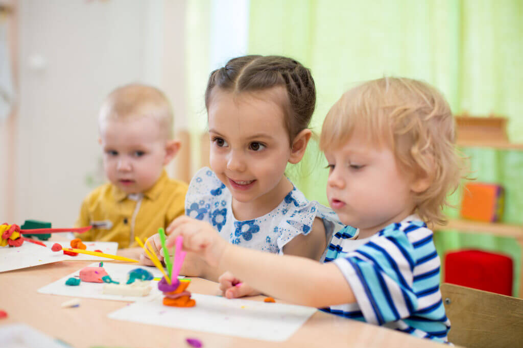 Kinder spielen mit Knete.