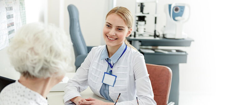 Ärztin spricht mit älterer Patientin.