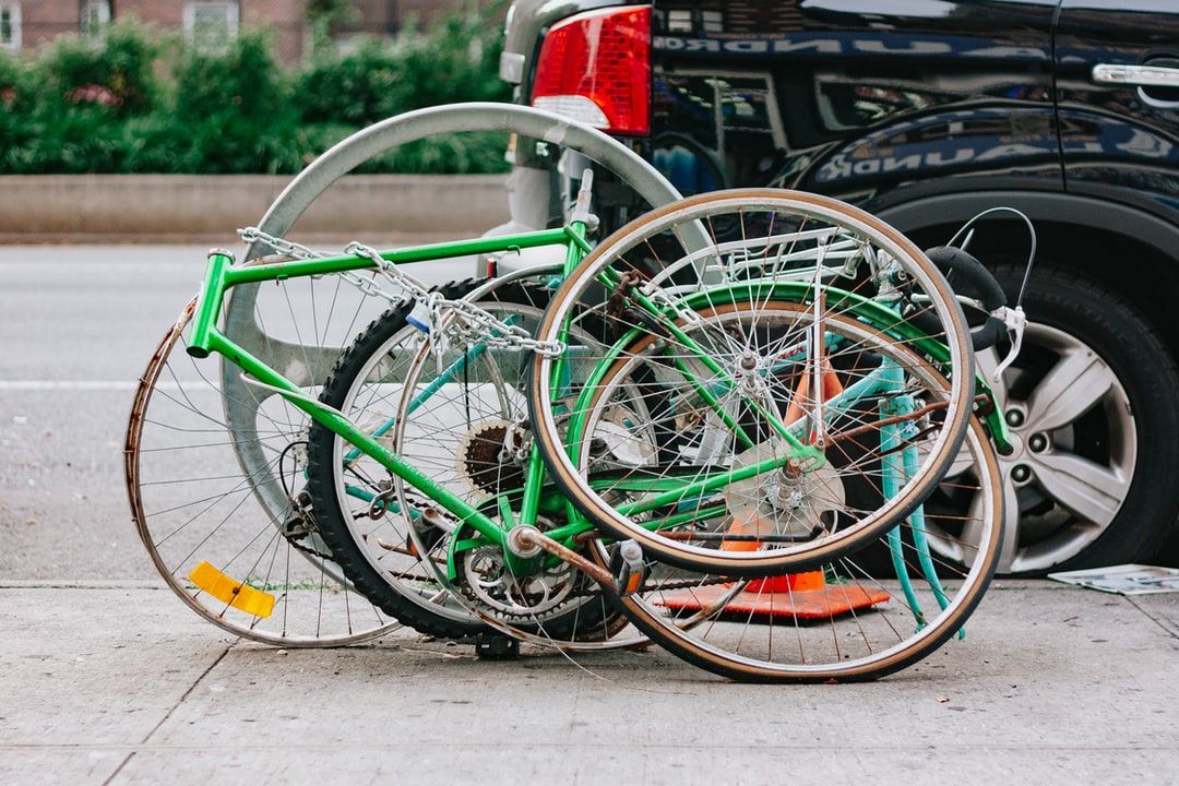 A collection a bicycle parts tangled together on a high street in Harlem