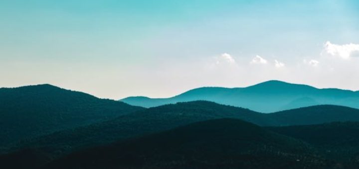 misty mountains with blue sky and white clouds
