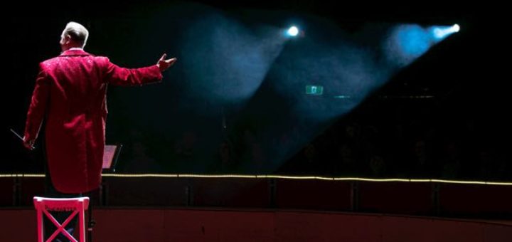 man standing on a chair on a stage