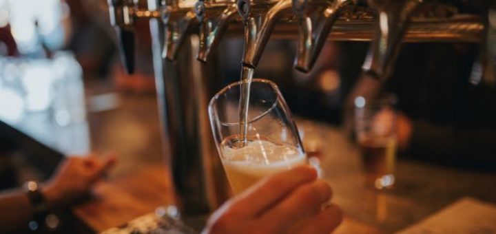 bartender pouring draft beer in a pub