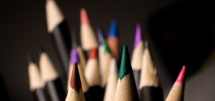 color pencils pointing up on a desk