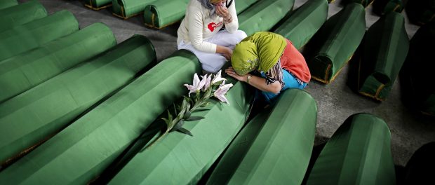 Bosnian Muslim women cry near the coffin of their relative, which is one of the 175 coffins of newly identified victims from the 1995 Srebrenica massacre, in Potocari Memorial Center, near Srebrenica