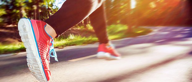 Woman runner jogging down an outdoor trail