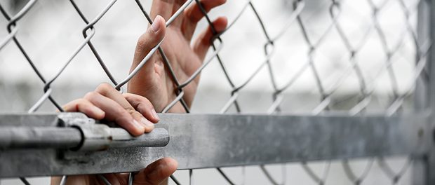 Woman hand holding on chain link fence for remember Human Rights