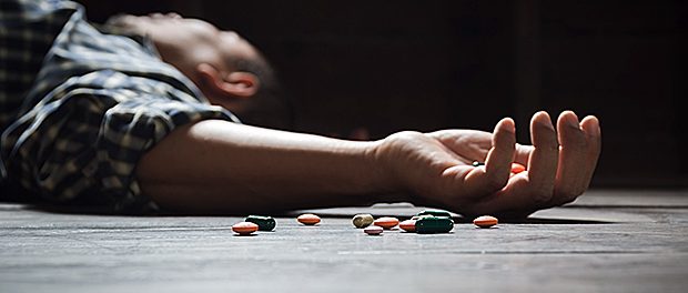 The man committing suicide by overdosing on medication. Close up