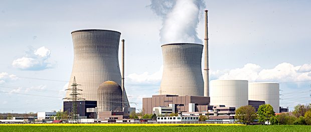 Nuclear power plant with yellow field and big blue clouds.