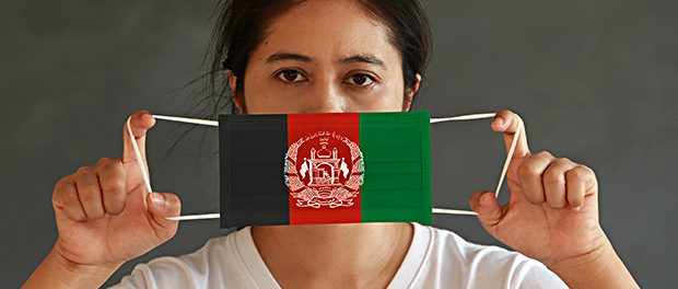A woman in white shirt with Afghanistan flag on hygienic mask in