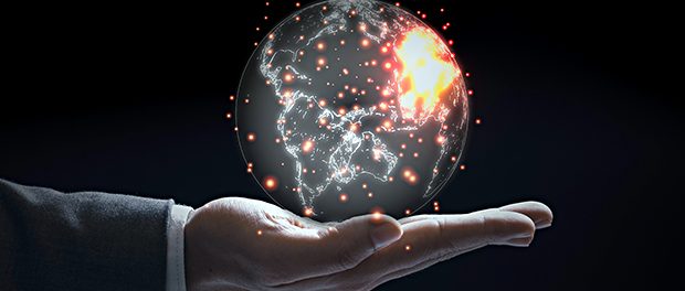Businessman holding world with orange flare on black background.