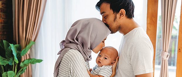 muslim parent kissing together with baby boy