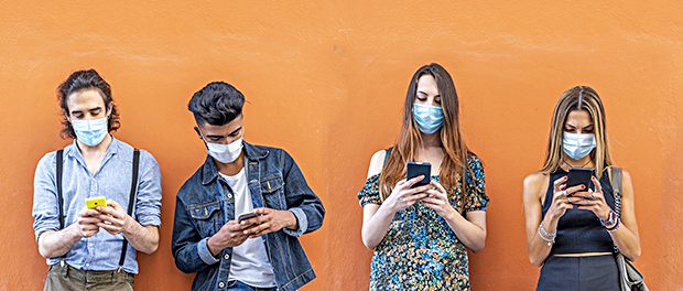 group of multiracial friends with face masks in front of orange