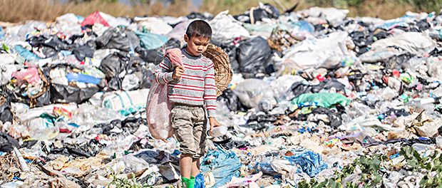 Poor boy collecting garbage in his sack to earn his livelihood,