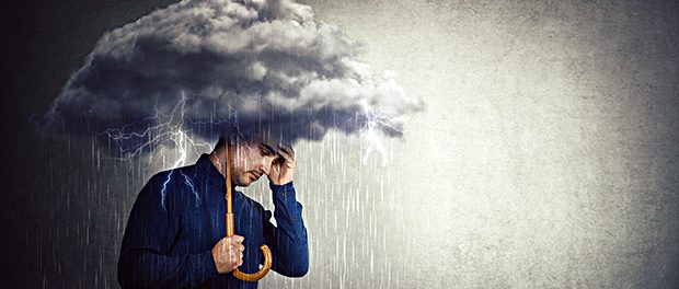 Pessimistic man, standing under rain, suffering anxiety as holdi