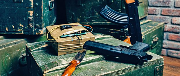 Bomb, knife, gun and rifle on box of ammunition