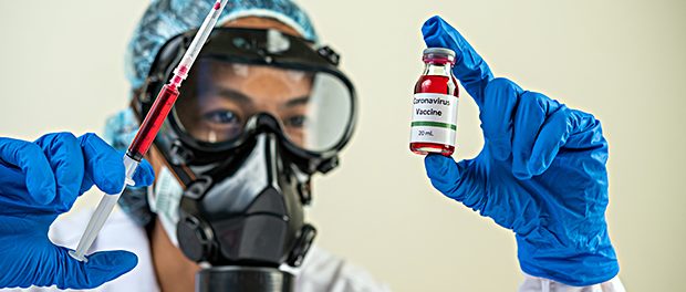 Scientists wearing masks and gloves Holding a syringe with a vac