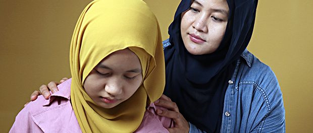 Muslim mother comforting her sad daughter, supportive mom help h