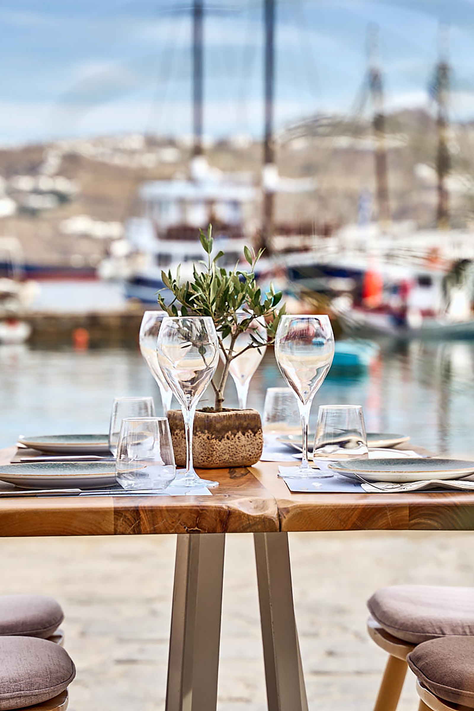 Making good use of natural elements, such as wood and wicker, and with earthly tones against a totally white background, Raya Mykonos provides its guests with a relaxing setting just on the shore of Mykonos Town. - Image