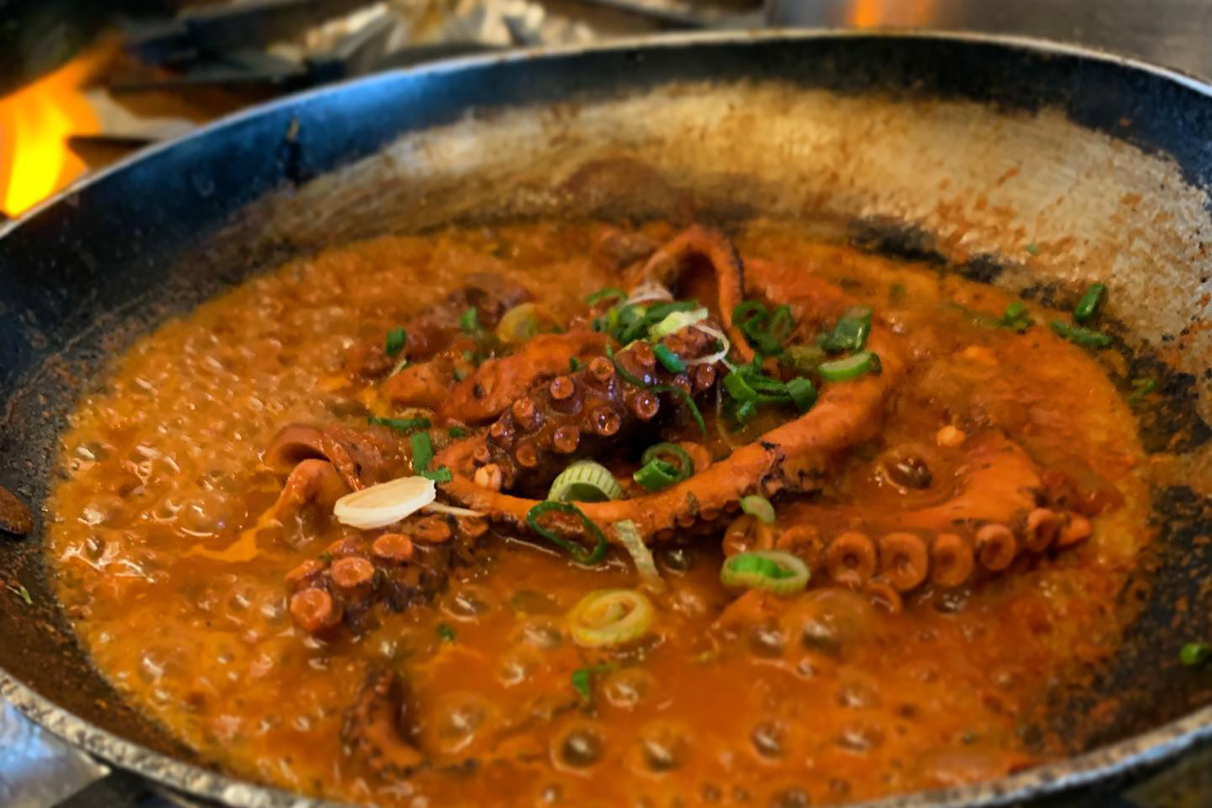 Do give the Mykonian louza (a type of local charcuterie) and sausage a try, as well as the fried zucchini balls and the feta in crust with honey and sesame. The menu boasts a large variety of fish, seafood, meat, pasta and traditional Greek dishes, so almost everyone will find for sure a personal favourite in this picturesque little seaside tavern. - Secondary Image