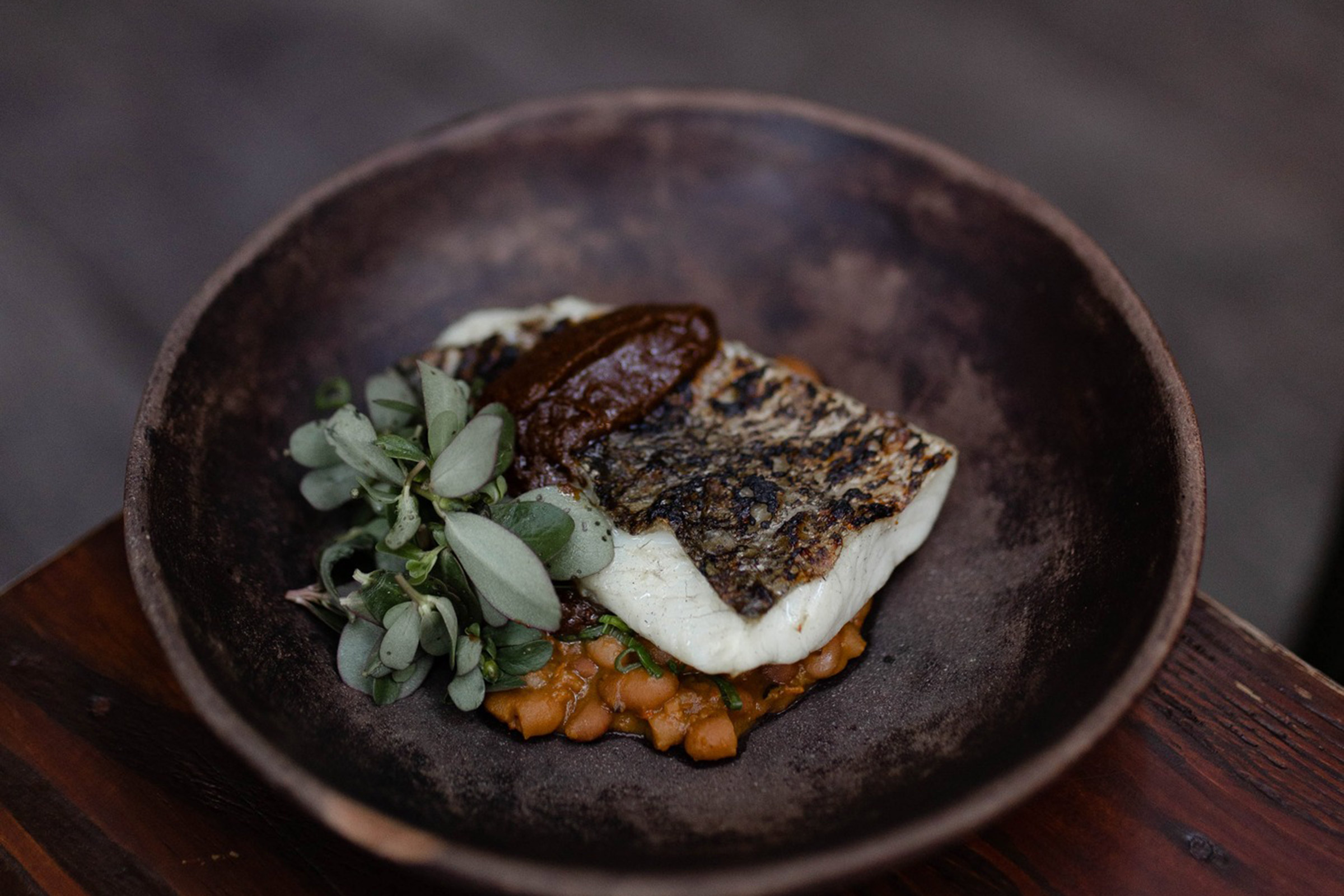 The best produce from the sea and the land takes its place over the wood-burning flames, offering guests a true taste of the local gastronomical culture and ways as they once used to be, way before it was cool. - Secondary Image