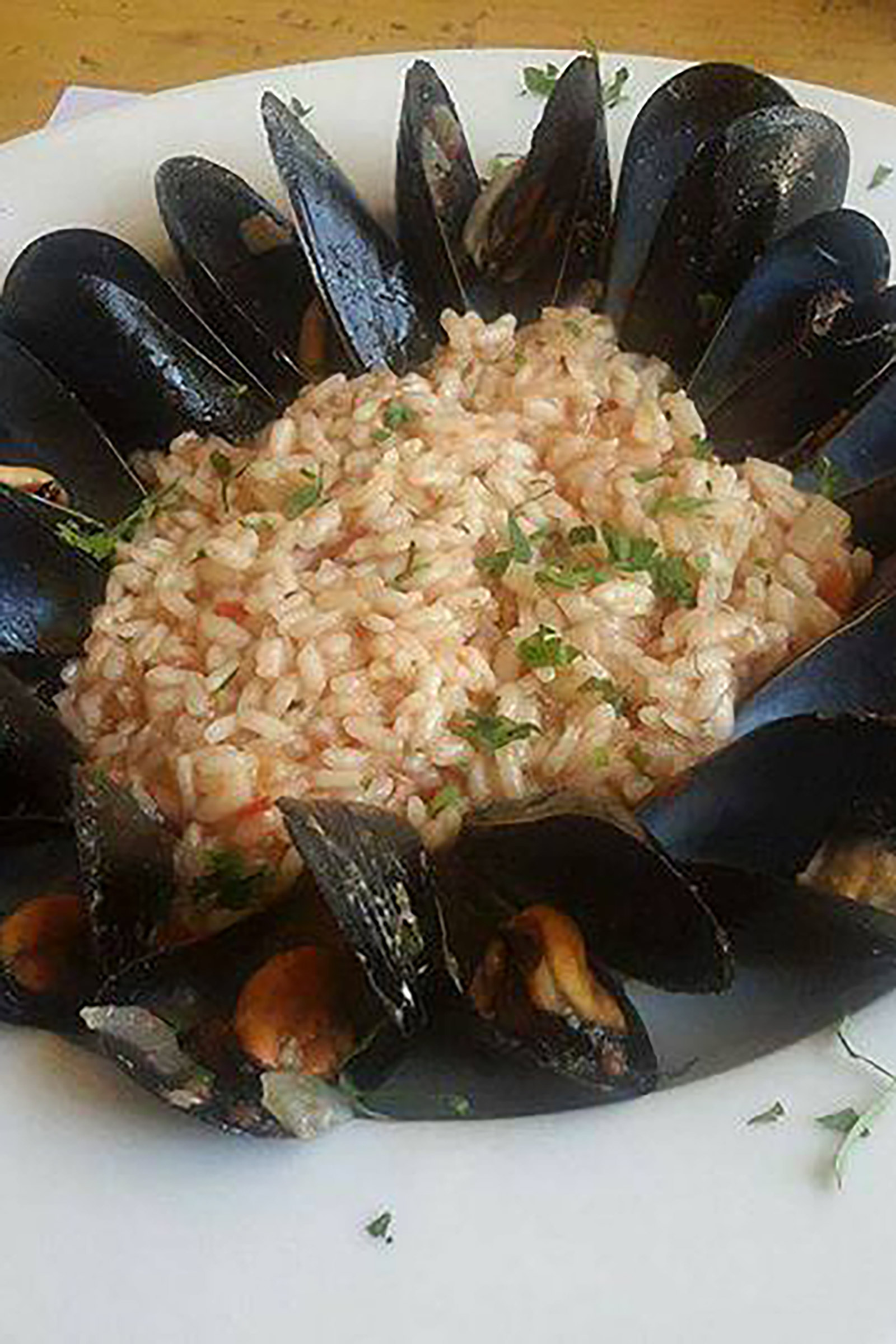 Shrimp pasta, steamed mussels, fresh Greek salad with feta cheese, fried kalamarakia, grilled fish and fresh squid, daily specials and many more delicious dishes enjoyed with your feet buried in the sand and your eyes gazing at the emerald sea shining under the strong Greek sun all summer long. - Image