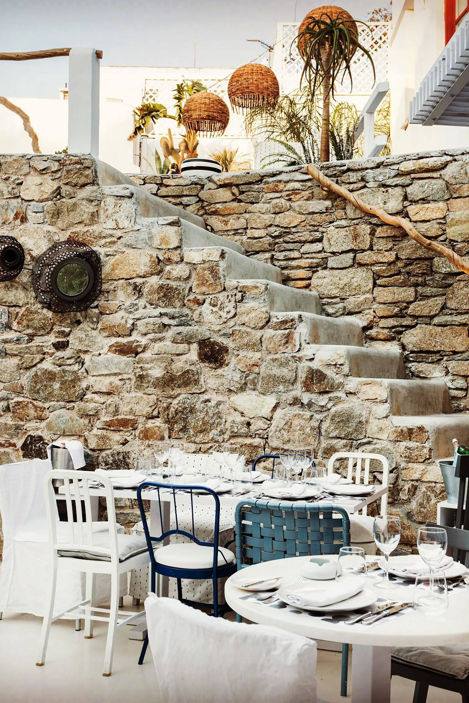 One of Mykonos’ most fashionable restaurant bars has been created by the world-famous designer and architect Paola Navone, combined with the personal touch of Greek high-design connoisseur, entrepreneur, and owner Nikos Varveris, which resulted in a stunning venue ticking all the right style boxes and speaking right to the heart of the elegant, sun-kissed, sophisticated crowd, frequenting this iconic meeting-point of the Mykonos’ nightlife. - Image