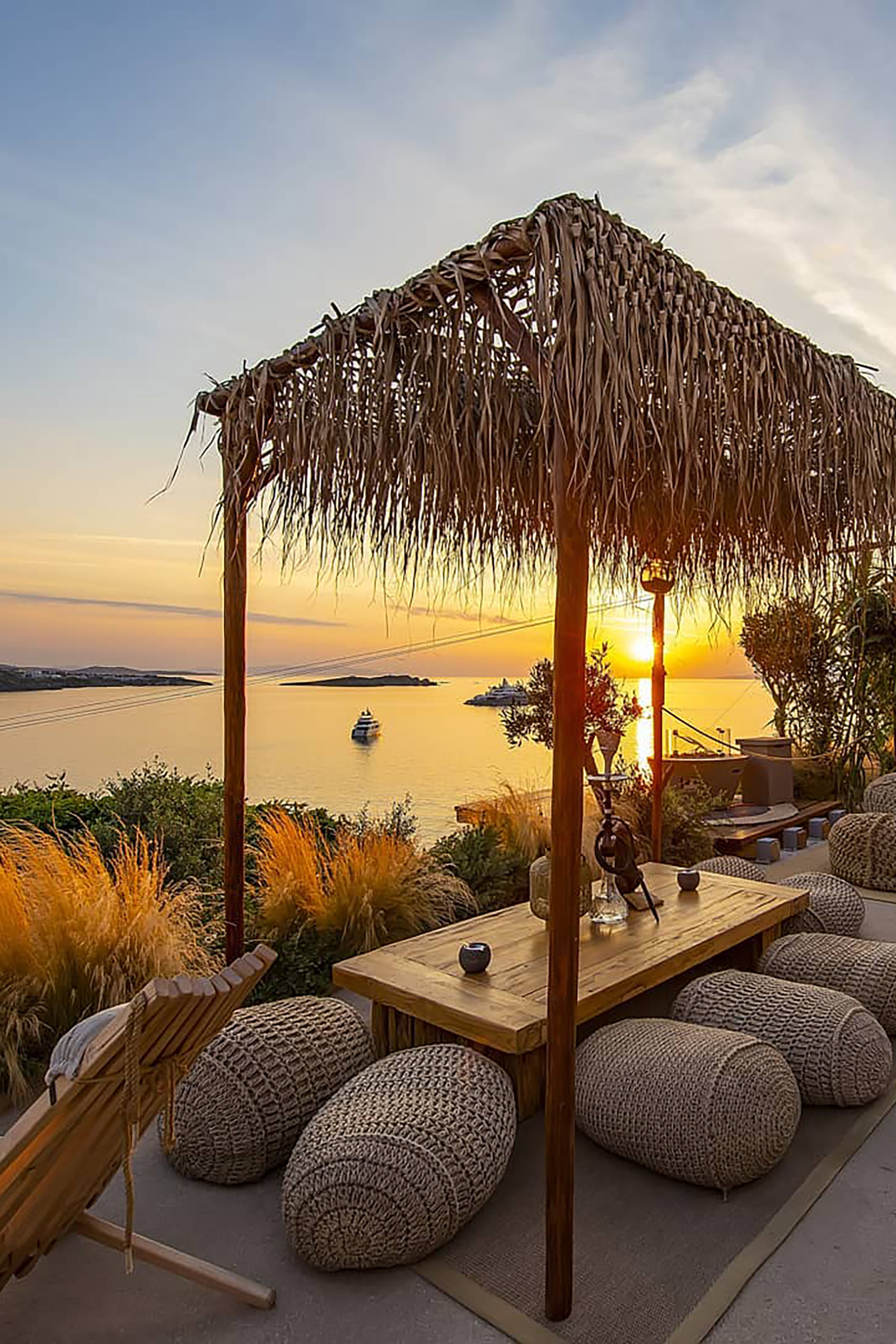 Earth tones and serene colours, natural wood and wicker, bohemian-chic surroundings and an elegant laid-back vibe makes The Garden of Mykonos a perfect choice for sunset chilling, paired with amazing cocktails served in handmade glassware and delicious snacks. - Image