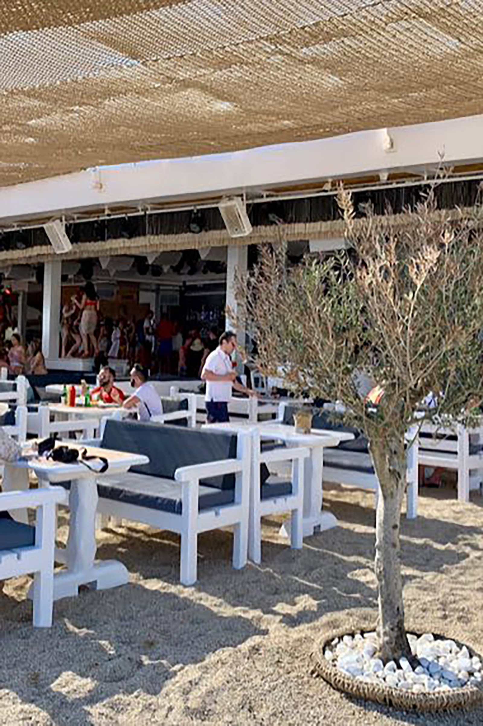 The crowd is young and beautiful, multi-culti and unpretentious, free and wild, sipping every last drop of this unique fun experience on one of the most beautiful beaches in the world, serving as the perfect background for your newly built summer memories. - Image