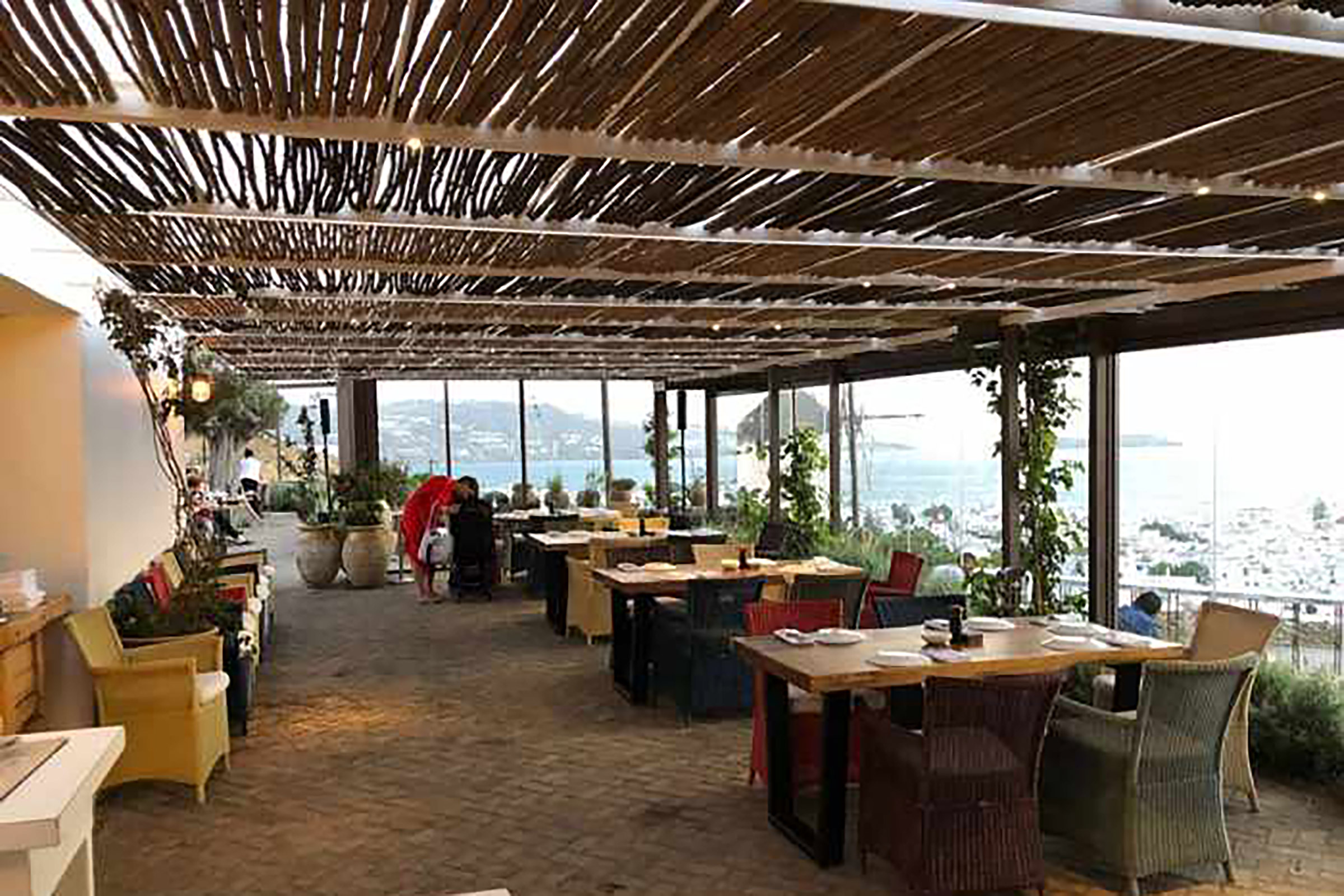 The Mykonos Town restaurant offers exquisite town and sea views, with a vast outdoor seating arrangement permitting for alfresco meat-centred feasts, frequented by celebrities, VIPs, and sworn meat-lovers alike. - Secondary Image