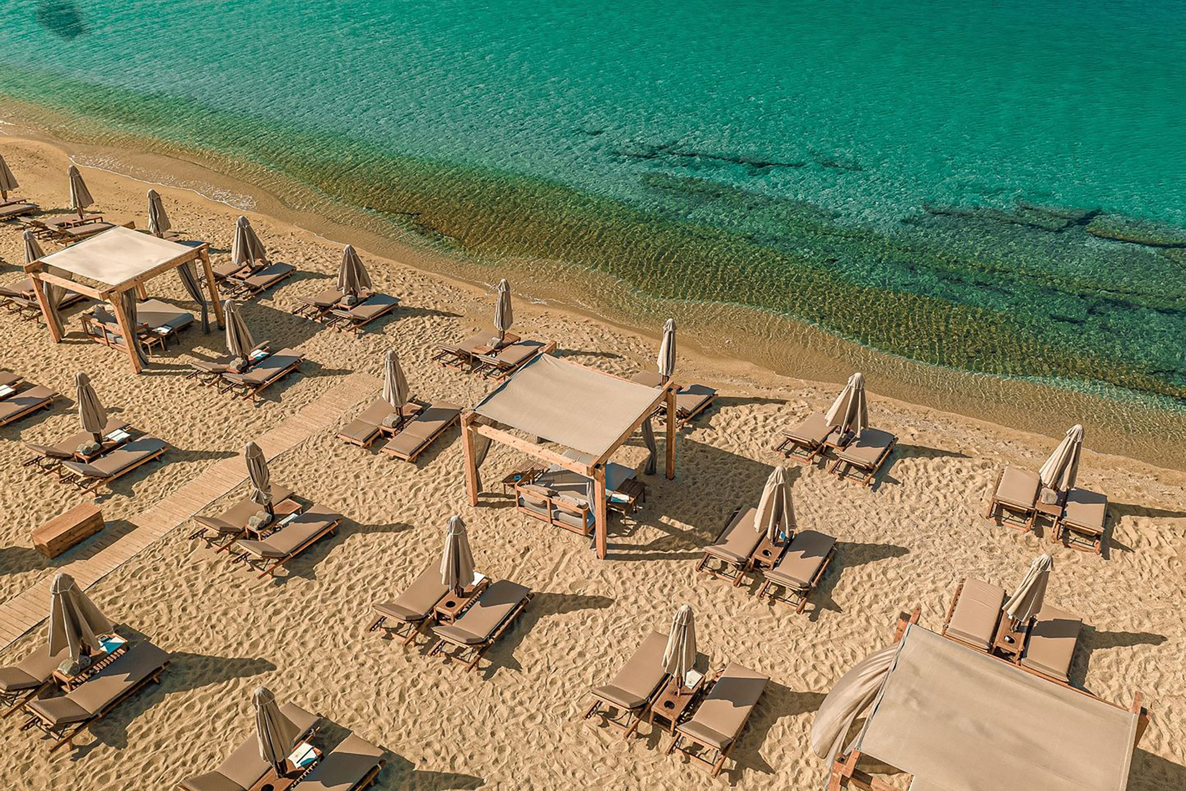 Branco Mykonos delivers an exciting journey for all the senses, with the crystal-clear sea, the soothing sounds coming from the DJ’s deck and the friendly service completing the delicious puzzle, that will please families, romantic couples and joyful companies of friends alike. - Secondary Image