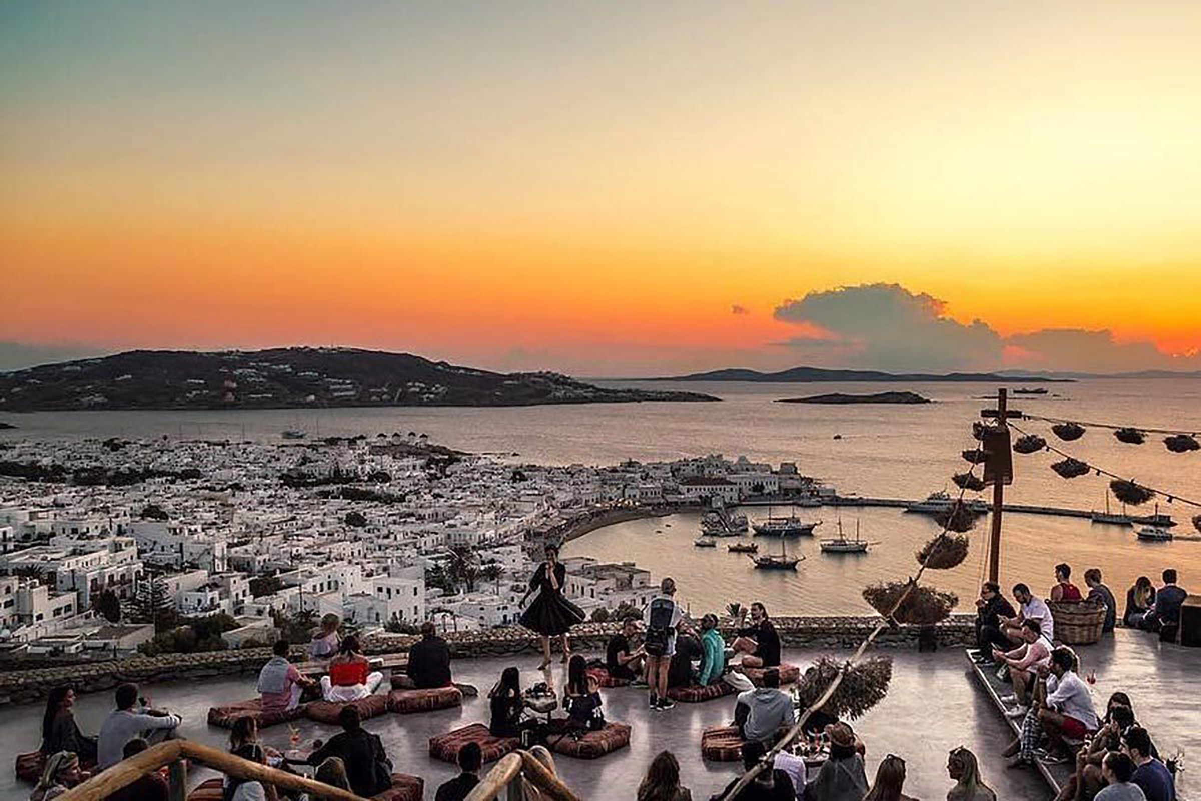 Located on the top of a hill overlooking Mykonos Town, this elegant, boho-chic, amazing venue is one of the most idyllic places to enjoy the sunset and get a much-promising night started. Designed to totally blend in with the surrounding natural landscape, 180° Sunset Bar offers a relaxing vibe from the first moment you set foot in it. - Secondary Image