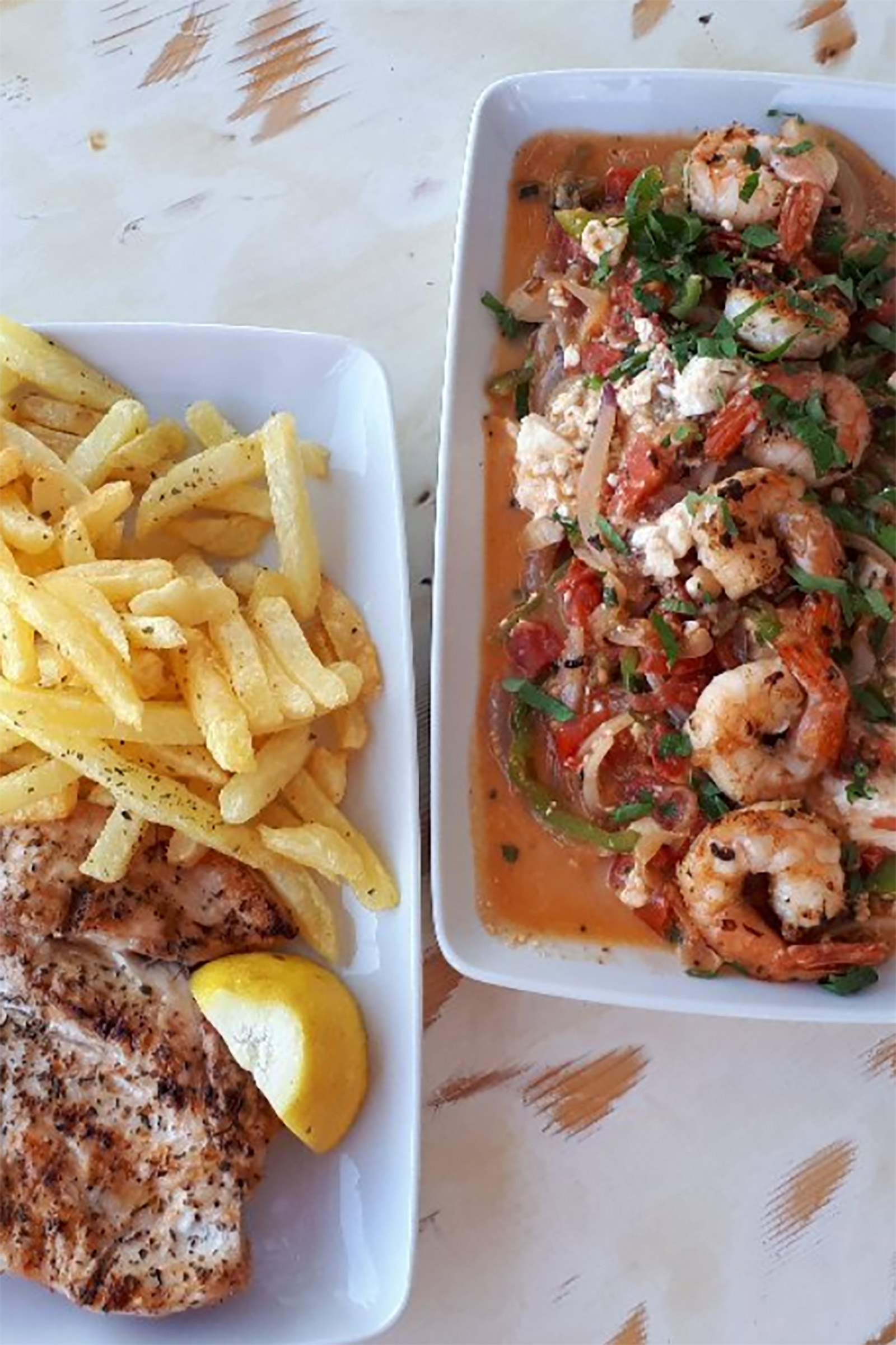 That -for any Greek- means fresh seafood, such as fried kalamarakia, grilled kalamari, grilled or vinegar-boiled octopus, large grilled fish, and traditional Greek dishes, such as gemista (stuffed vegetables with rice and herbs), moussaka (aubergines with minced beef and cream) or kokkinisto (meat cooked in tomato sauce and served with pasta or French fries). - Image