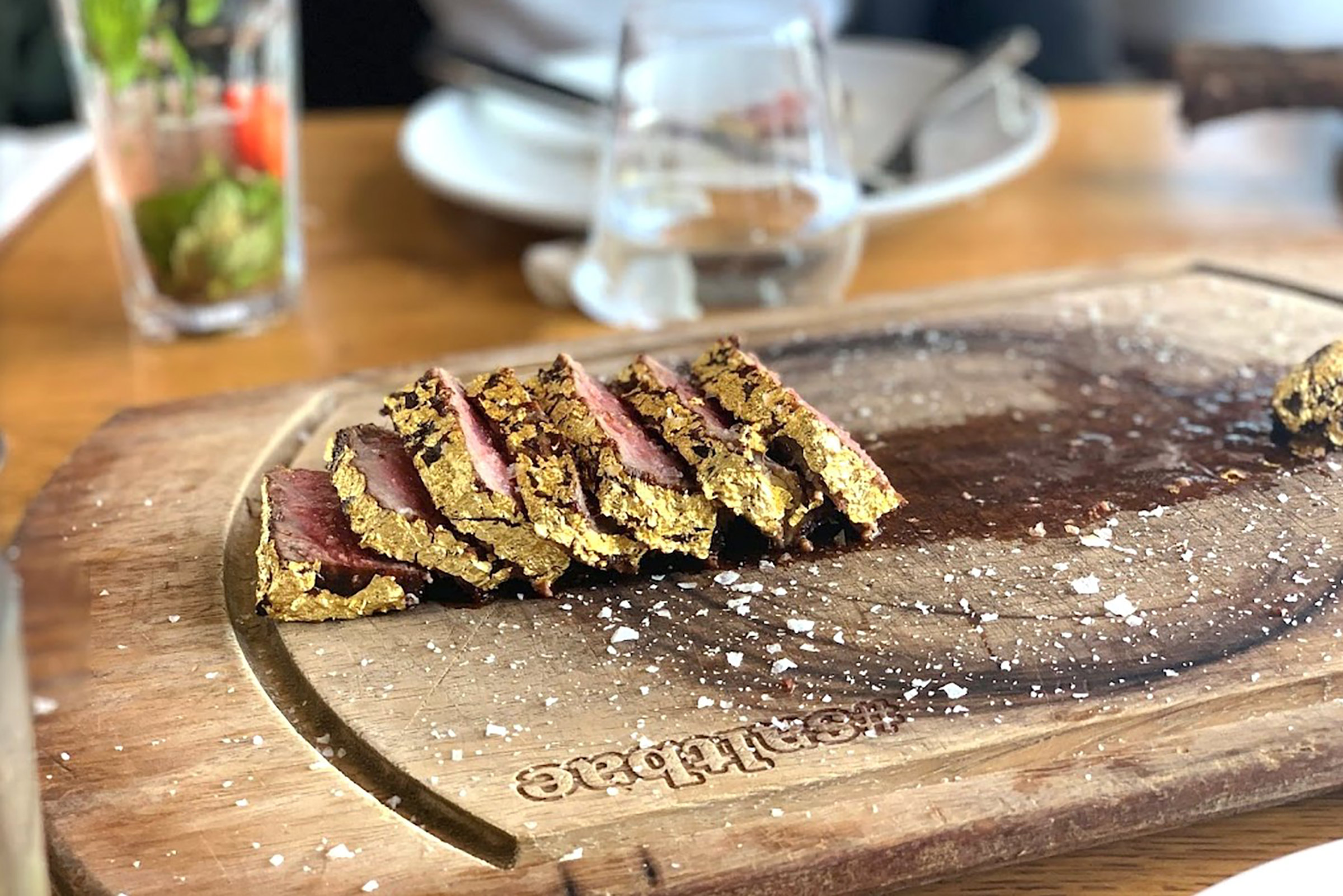 The Mykonos Town restaurant offers exquisite town and sea views, with a vast outdoor seating arrangement permitting for alfresco meat-centred feasts, frequented by celebrities, VIPs, and sworn meat-lovers alike. - Secondary Image