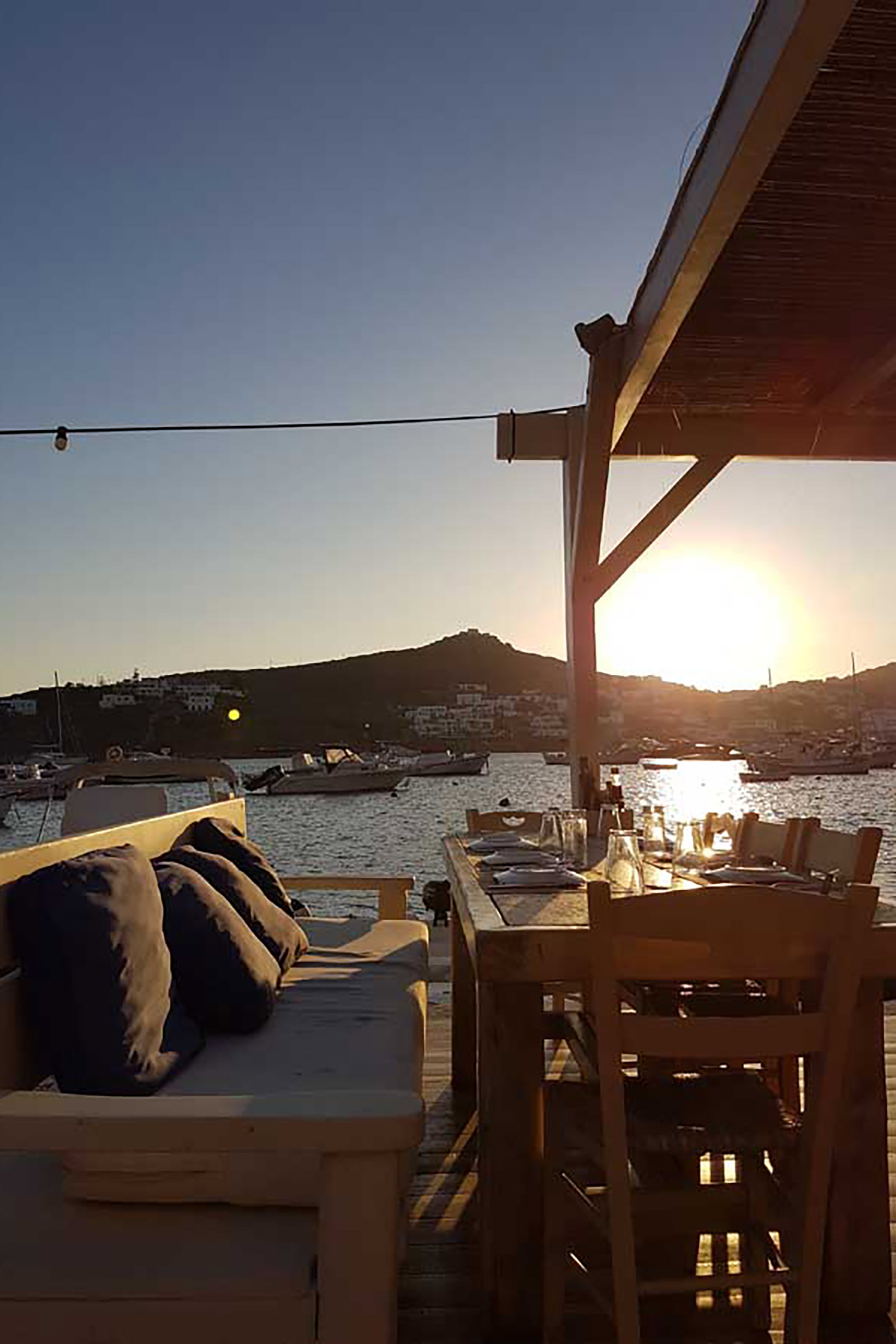 In a rather elegant setting and literally touching the sea, Apaggio restaurant, located on Ornos beach, has been serving Greece in a plate since 2013. It purposely keeps music at very low volume, so guests can dine listening to nothing but the magical sound of the sea. - Image