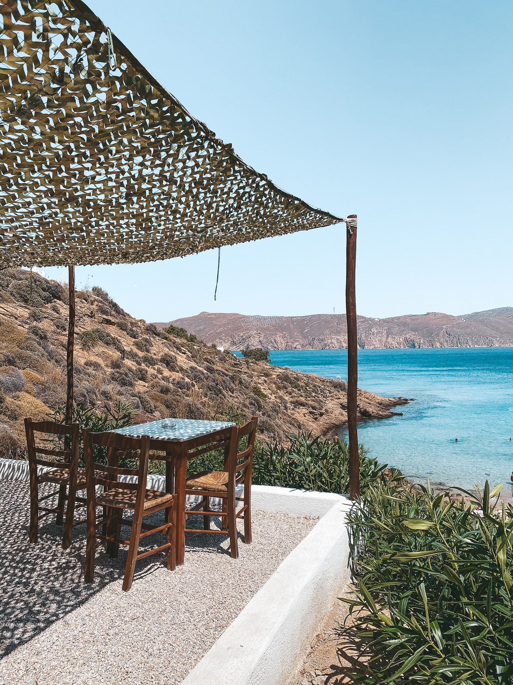 Over the one end of the heavenly and unspoiled gold-sanded beach of Aghios Sostis, where the island’s insiders and savants come to swim naked at the edge of the small cove and feel one with mother nature, stands a traditional tavern that looks more like a treehouse, has no electricity, no phone and applies a strict “first come, first serve” policy. - Image