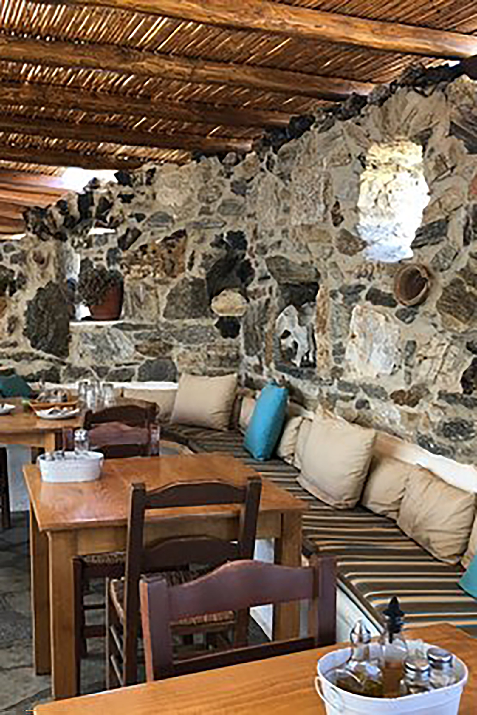 Far away from the loud and glamourous Mykonos party scene, here you will find yourself diving in and out the pristine waters all day long and then taking a seat at a perfect view table with the sand still between your toes and your hair still wet from the sea. - Image