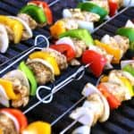Stokjes souvlaki met rode en gele paprika en rode ui op de grill.