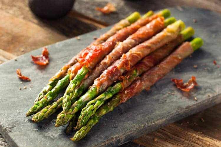 Deze groene asperges met parmaham zijn super lekker en makkelijk om te maken. Je kunt de asperges serveren als bijgerecht tijdens het kerstdiner! #koolhydraatarm #bijgerecht #asperges