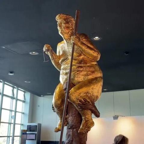 Shot of same statue from the front. You can see Trump is holding tiny justice scales in his other hand.