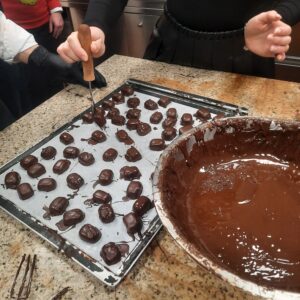 We’re dipping the semi-finished Christmas candies in chocolate at BPO’s Christmas party.