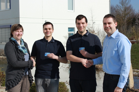 Training Leader Kerstin Langohr and Jürgen Weiland, Vice President of Software Development - Information Management Solutions (far right in picture), congratulate the two fledging IT experts in application development.