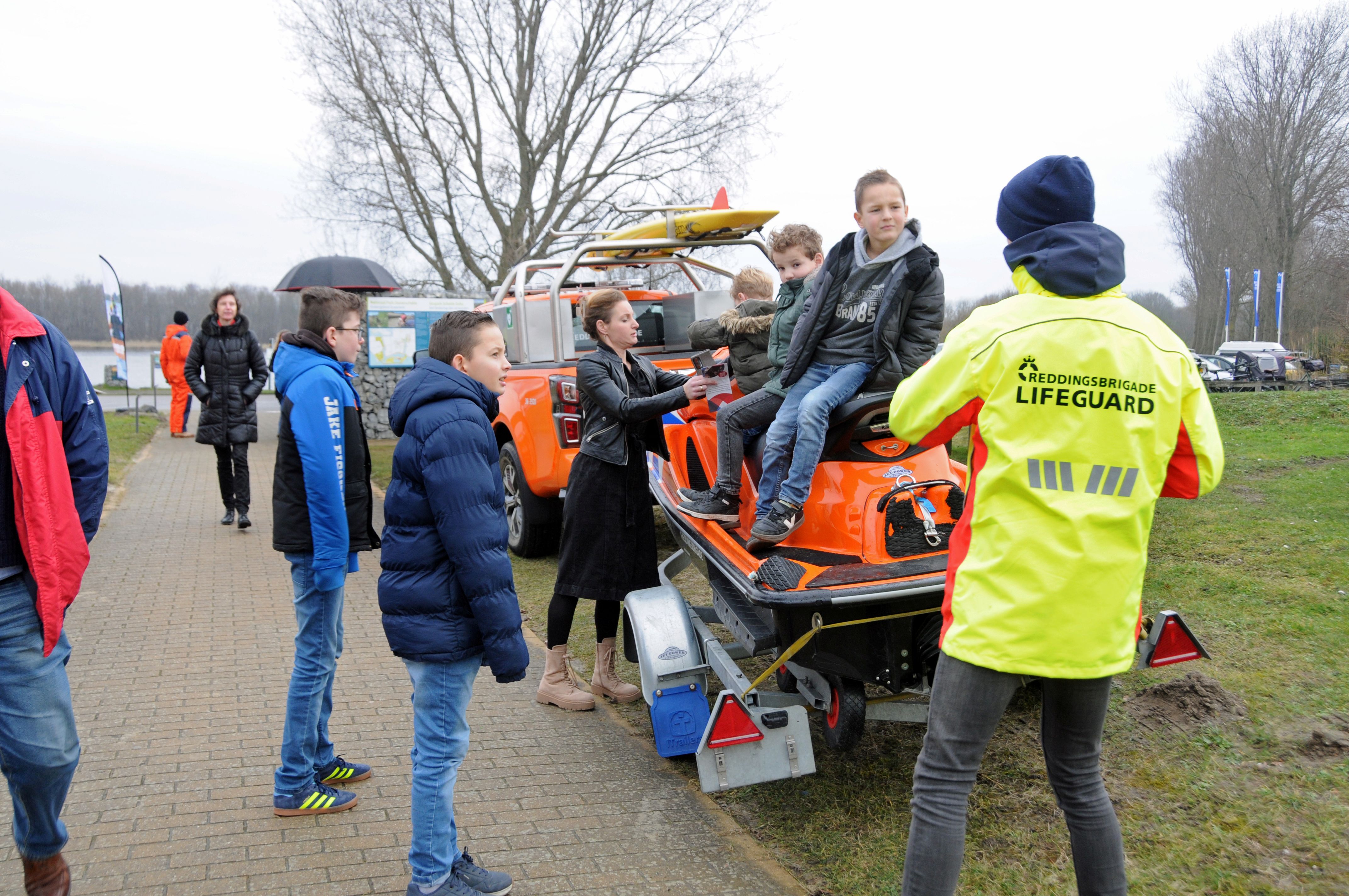 Kinderen op een jetski met iemand van de reddingsbrigade.
