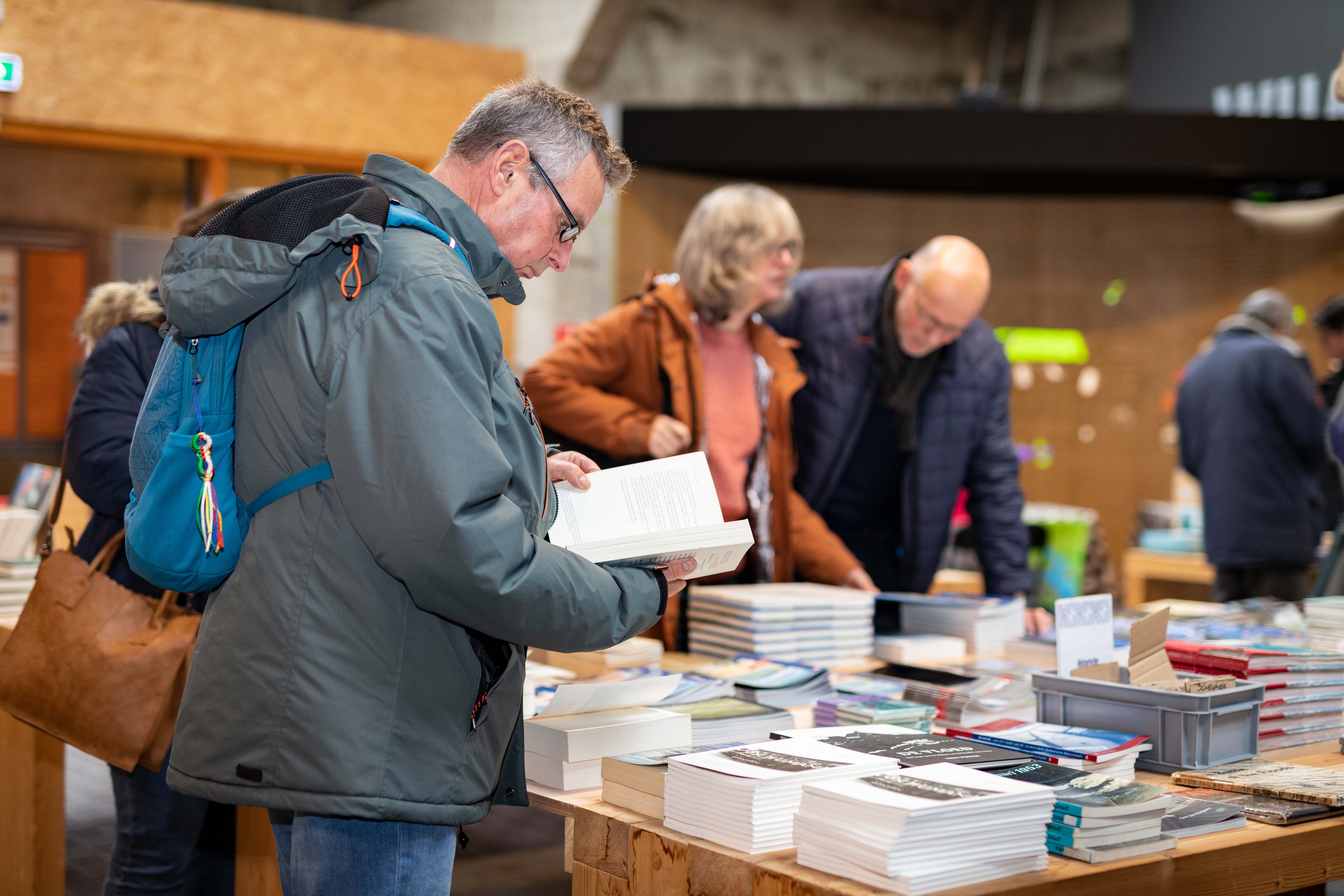 Een man kijkt in een boek in de museumwinkel.