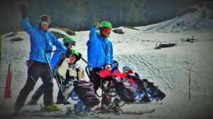 maestri di sci con disabili sulla neve
