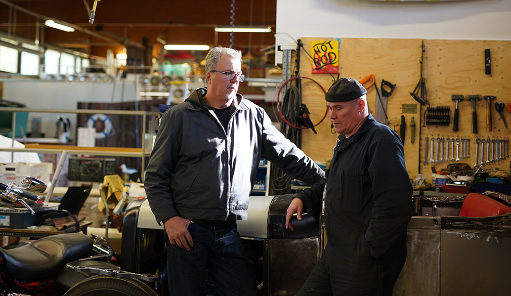 Masi Jukosella (vas.) on työn alla vuoden 1928 Ford roaster. Kari Saarela on tehnyt siihen peltitöitä.