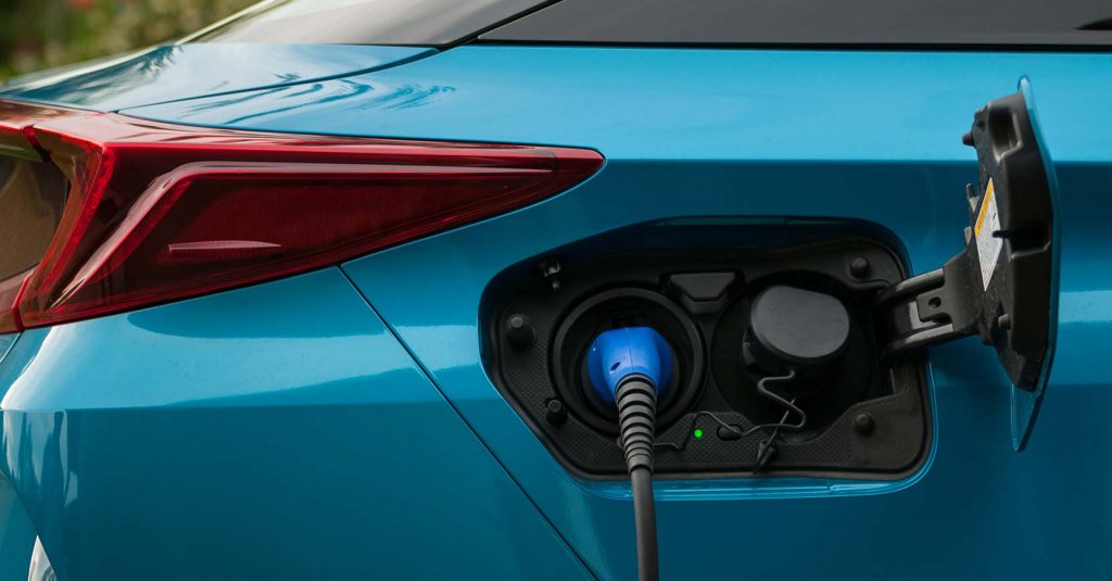 sininen hybridiauto jonka latauspistoke on auki